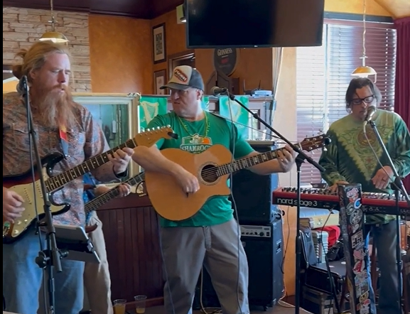 A band performing with two guitars and a keyboardist at Kip's Irish Pub