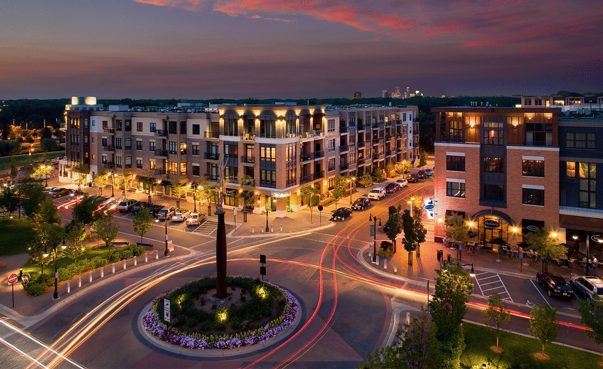 Excelsior & Grand at night with view of downtown skyline