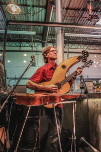 Man playing a unique guitar