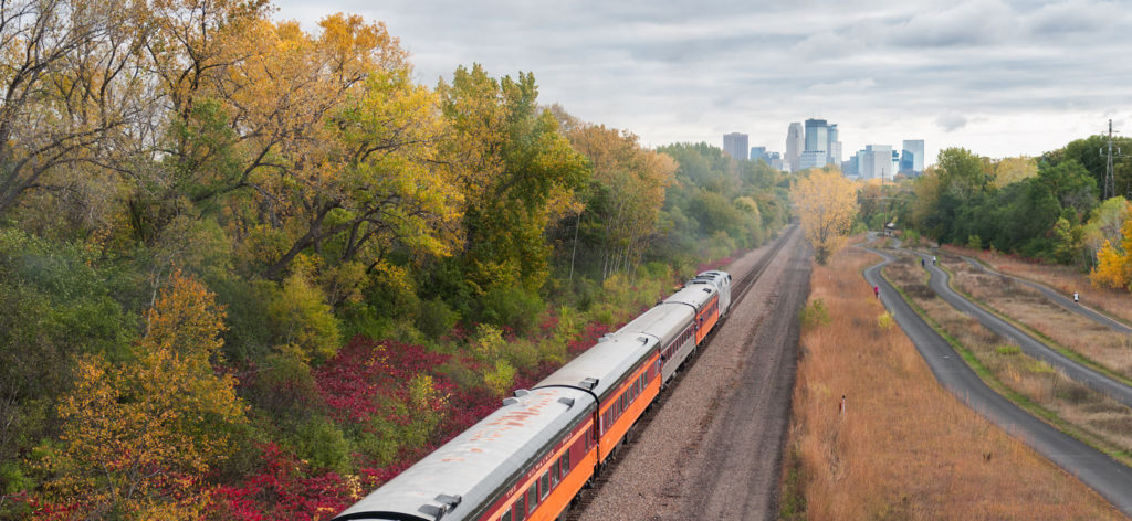 Cedar Lake Trail in the fall alongside of a train with a view of Minneapolis 