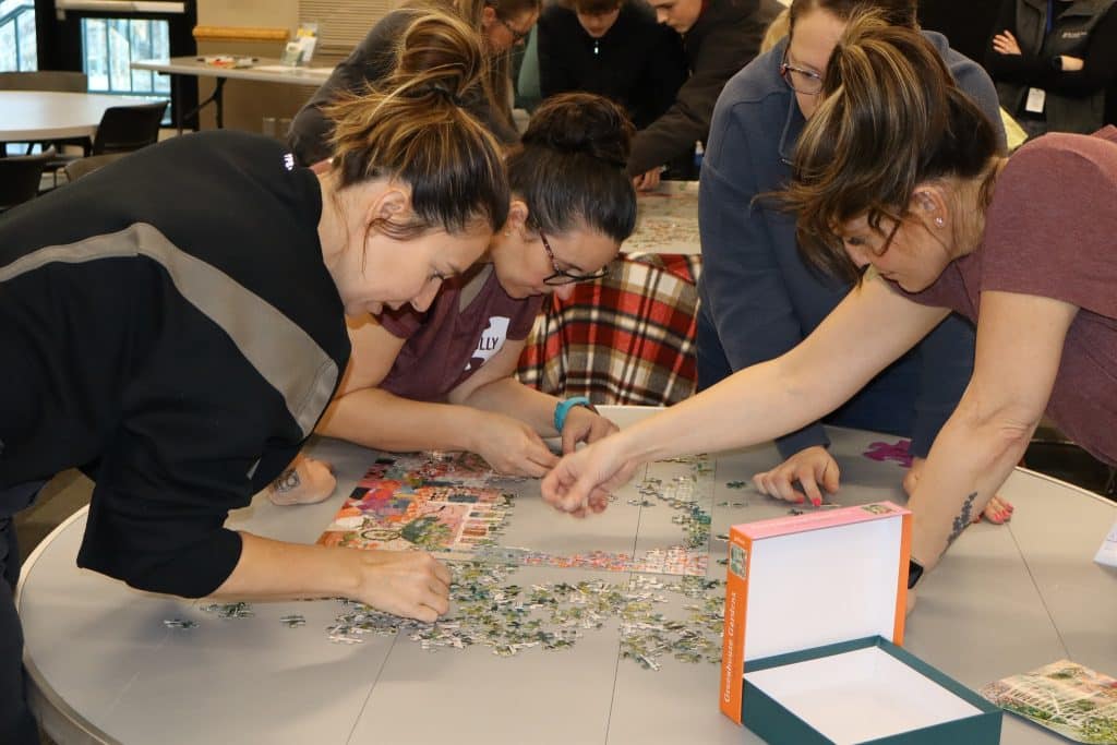 A team of 4 people race to complete a jigsaw puzzle in the shortest amount of time at Puzzlepalooza