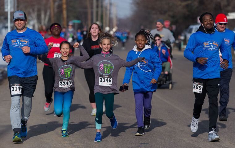 Kids and adults running down a road as part of the Run the Valley event