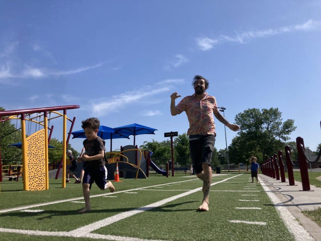 A parent and child racing each other on the obstacle course at Schaper Park in Golden Valley