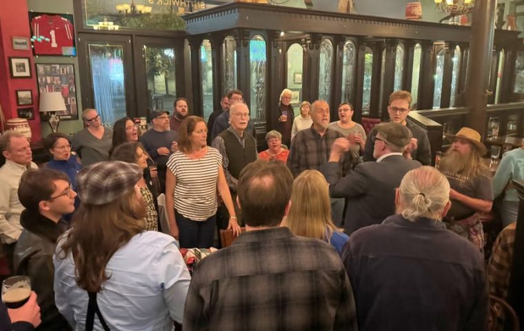 A large group of people gathered round to sing sea shanties at The Local in St. Louis Park