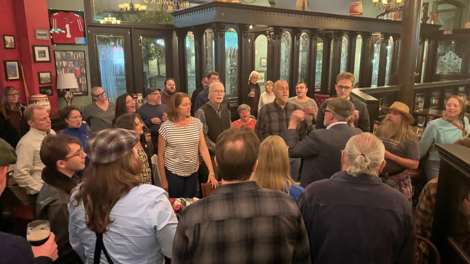A large group of people gathered round to sing sea shanties at The Local in St. Louis Park