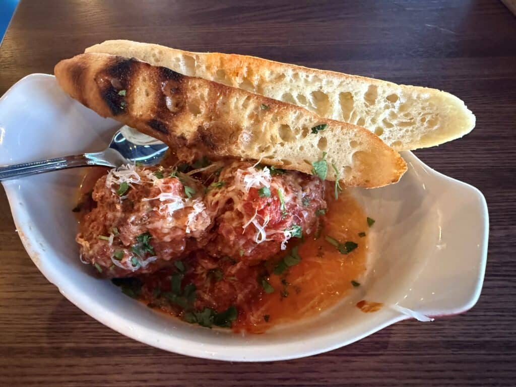Nana's meatballs topped with parmesan cheese and served with toasted bread at Kitchen and Rail in Golden Valley