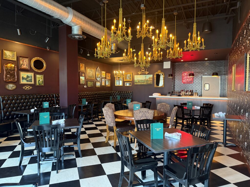 The private dining area with an array of seating options, elegant chandeliers, private bar, and seating for 50 at Kitchen and Rail in Golden Valley