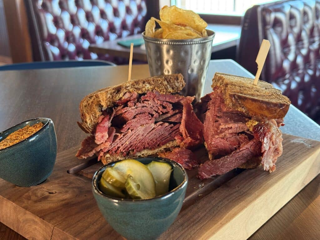 The Mort sandwich made with a half pound of NY-style pastrami on caraway rye served with pickles, mustard and kettle chips at Kitchen and Rail in Golden Valley